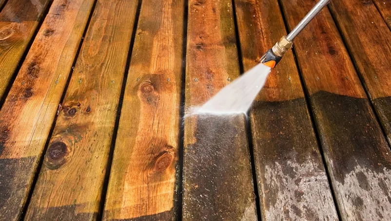 Power washing an outdoor wooden deck.