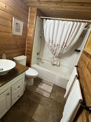 Home cleaning professionals deeply scrub bathroom floor tiles and deep clean entire bathtub and toilet. 